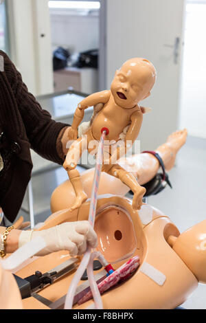 La prestation d'un étudiant sage-femme mannequin bébé à partir d'un mannequin adulte, les deux mannequins sont équipés de capteurs, de son et d'autres dispositifs conçus pour simuler un grand nombre des conditions de l'accouchement, Limoges, France. Banque D'Images