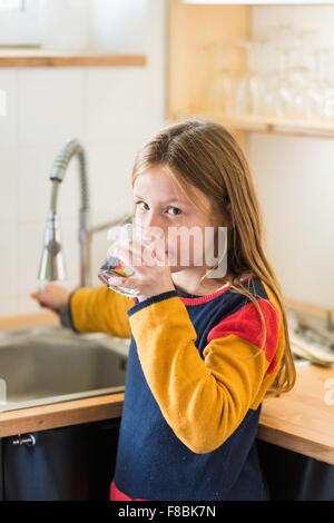 Petite fille de 9 ans l'eau du robinet. Banque D'Images