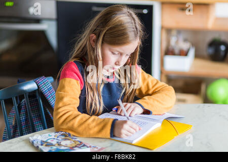 Petite fille de 9 ans fait ses devoirs. Banque D'Images