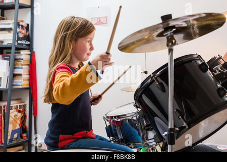 Petite fille de 9 ans à jouer de la batterie. Banque D'Images