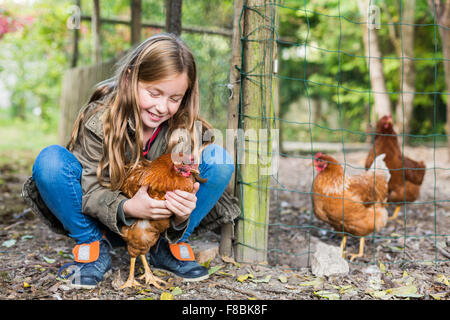 Petite fille de 9 ans avec des poules. Banque D'Images