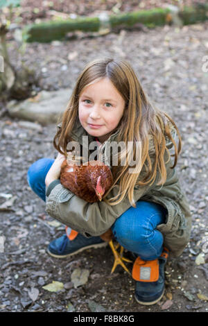 Petite fille de 9 ans avec des poules. Banque D'Images