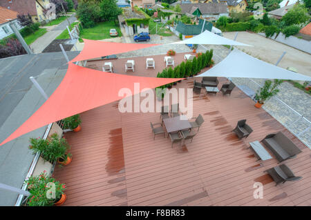 Terrasse en été avec des voiles d'ombre, des fleurs et des chaises longues Banque D'Images