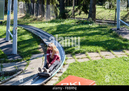 Jeune femme équitation sur PKL luge gravité sur la Colline Gubalowka, Zakopane, Pologne, Europe Banque D'Images