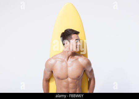Muscular man holding voile jaune derrière son dos Banque D'Images