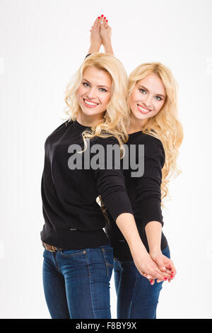 Belle jeune blonde sœurs jumeaux posant sur fond blanc Banque D'Images