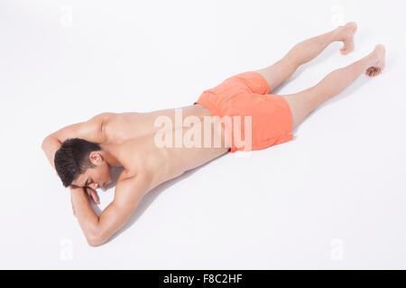 High angle de l'homme musclé en natation de pantalon reposant sa tête sur ses mains Banque D'Images