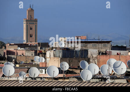 Des antennes paraboliques sur les toits de Marrakech, Maroc. À l'arrière-plan une mosquée et les montagnes du Haut Atlas Banque D'Images