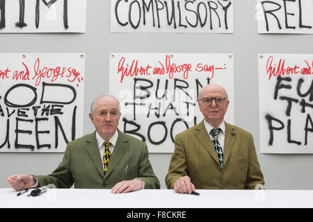 Londres, Royaume-Uni. 8 décembre 2015. Sur la photo : de gauche à droite : Gilbert & George en face de leurs œuvres les bannières pour assister à une séance de signature. Artistes Gilbert & George lancer leur dernière publication les bannières, ainsi que 10 modèles d'affiches, de faire coïncider avec leur exposition au White Cube Bermondsey. L'exposition Les bannières se déroule du 25 novembre 2015 au 24 janvier 2016. Banque D'Images