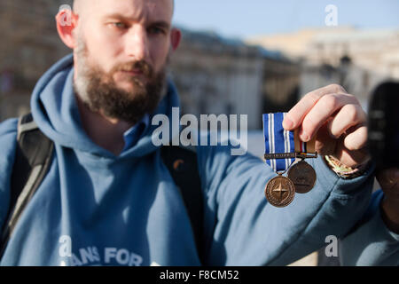 Londres, Royaume-Uni. 8 Décembre, 2015. Daniel Lenham, qui a servi dans la RAF de 2002 à 2014, notamment en Irak et en Libye, est titulaire des médailles à être jeté par lui devant Downing Street pour protester contre les frappes sur la Syrie. Credit : Mark Kerrison/Alamy Live News Banque D'Images