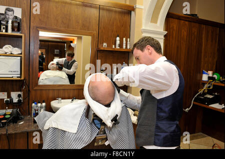 L'homme reçu une serviette chaude de rasage coiffure à Londonderry, en Irlande du Nord. Banque D'Images