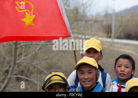 Les enfants tibétains jouant avec un drapeau rouge au Tibet Banque D'Images