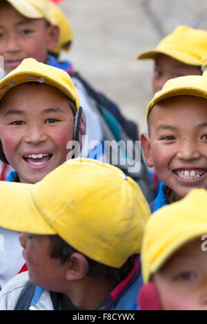 Les enfants tibétains jouant avec un drapeau rouge au Tibet Banque D'Images