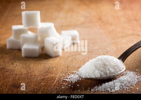Sucre blanc en cuillère en argent sur table en bois Banque D'Images