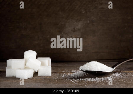 Sucre blanc en cuillère en argent sur table en bois Banque D'Images