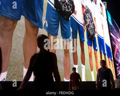 Silhouette de personnes en face de l'écran numérique géant de la publicité commerciale dans le centre commercial de Dubaï, Dubaï, Emirats Arabes Unis. Banque D'Images