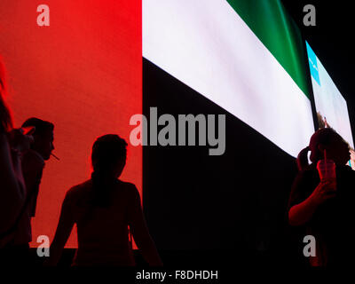 Silhouette de personnes en face d'eau géant (Emirats Arabes Unis) drapeau dans le centre commercial de Dubaï. Banque D'Images