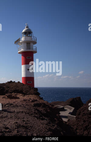 Phare rouge, blanc avec fond de l'océan on rock Banque D'Images