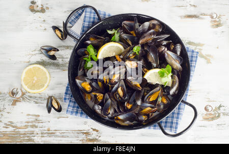 Marmite en cuivre de moules gastronomique servi sur une serviette garnie avec du citron et le persil. Vue d'en haut Banque D'Images