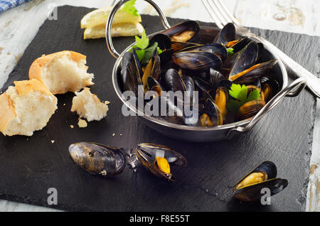 Les moules cuites dans un plat de cuisson sur fond sombre. Selective focus Banque D'Images