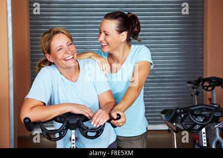 Deux femmes souriant debout dans une salle de spinning in a gym Banque D'Images