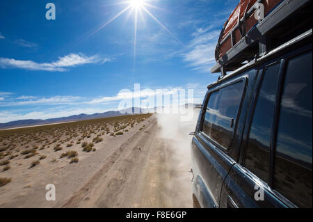 La conduite de véhicules hors route dans le désert d'Atacama, la Bolivie avec montagnes et ciel bleu dans la faune andine Eduardo Avaroa National Park Banque D'Images