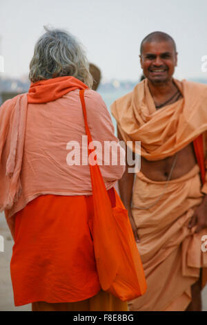 Deux moines locaux non identifiés en vêtements traditionnels chaque message d-autres sur les ghats, Inde Banque D'Images