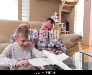 Le père et le fils de l'assemblage à jouet avion accueil moderne salle de séjour piscine Banque D'Images