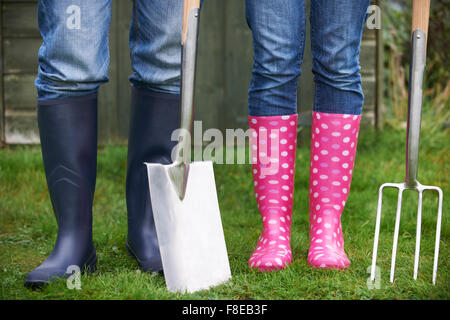 Près de Young Couple Holding Spade et fourchette Banque D'Images