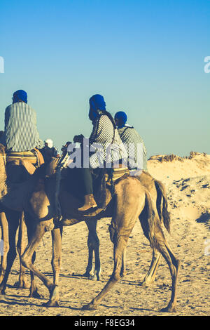 Beduins menant les touristes sur des chameaux à court-circuit touristique autour du début qu'on appelle portes du désert du Sahara Douz, Tunisie, Banque D'Images