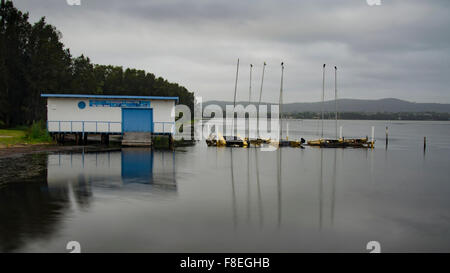 Louez des bateaux et un hangar à bateaux assis au bord de l'eau lors d'une journée nuageux à long Jetty, Nouvelle-Galles du Sud, Australie Banque D'Images