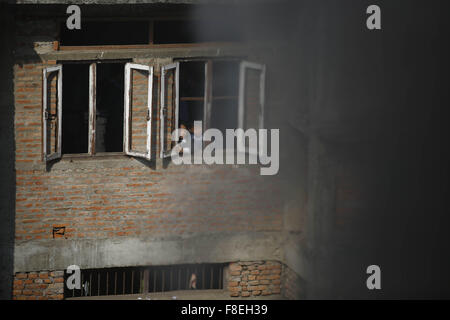 Katmandou, Népal. 9Th Mar, 2015. Les enfants de l'école regarder à travers une fenêtre dans Jhochhen Tole, Katmandou, Népal le mercredi, Décembre 9, 2015. Un violent incendie éclate dans un entrepôt électronique causés par des défaillances électriques. L'entrepôt avait surtout comme des fournitures de cuisine et autres articles de cuisson à induction pour le carburant en situation de crise en raison de la frontière entre des blocus. Il n'y avait pas de blessures causées dit selon les habitants. Photo/Skanda Skanda Gautam Gautam © ZUMA/wire/Alamy Live News Banque D'Images