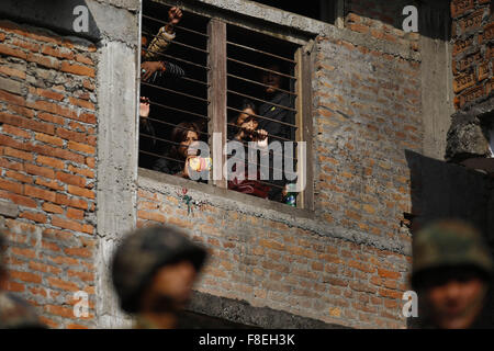 Katmandou, Népal. 9Th Mar, 2015. Les gens regarder à travers une fenêtre de l'école dans Jhochhen Tole, Katmandou, Népal le mercredi, Décembre 9, 2015. Un violent incendie éclate dans un entrepôt électronique causés par des défaillances électriques. L'entrepôt avait surtout comme des fournitures de cuisine et autres articles de cuisson à induction pour le carburant en situation de crise en raison de la frontière entre des blocus. Il n'y avait pas de blessures causées dit selon les habitants. Photo/Skanda Skanda Gautam Gautam © ZUMA/wire/Alamy Live News Banque D'Images