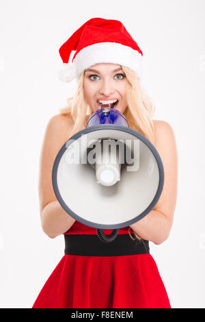 Portrait de jeune fille amusante joyeux Père Noël en robe et chapeau en parlant isolé sur fond blanc mégaphone Banque D'Images