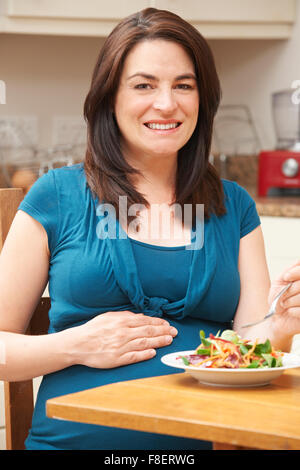 Pregnant Woman Eating Salade saine à la maison Banque D'Images