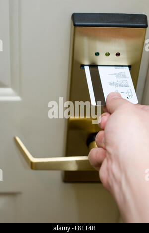 Photo de la main de personne clé de l'insertion d'une carte dans un système électronique de porte de l'hôtel serrure de sécurité pour déverrouiller la porte. Banque D'Images