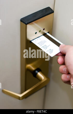Photo de la main de personne clé de l'insertion d'une carte dans une chambre d'hôtel serrure de sécurité électronique de la porte pour déverrouiller la porte. Banque D'Images