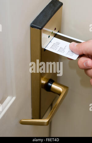 Chambre d'hôtel serrure de sécurité électronique de la porte avec sa main l'insertion d'une carte clé pour déverrouiller la porte Banque D'Images