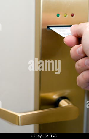 Chambre d'hôtel serrure électronique avec une personne de la main à l'aide d'une bande magnétique carte clé pour déverrouiller la porte Banque D'Images