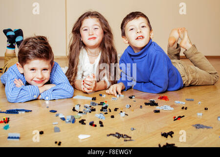 Funny cute enfants jouant à la maison lego, garçons et girl smiling, première éducation Banque D'Images