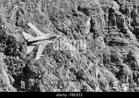 Photo en noir et blanc d'Un avion de chasse Tornado GR4 de la Royal Air Force volant à bas niveau à travers Une vallée du désert. Banque D'Images