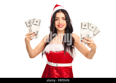 Jeune femme en costume Santa holding quelques piles de l'argent et regardant la caméra isolé sur fond blanc Banque D'Images