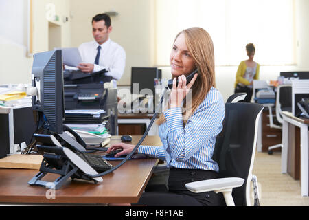 Businesswoman prenant Téléphone dans Bureau actif Banque D'Images