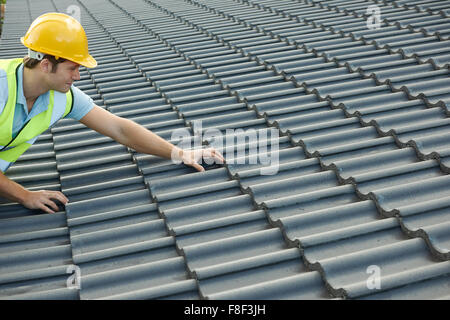 Builder travaillant sur toit de Nouveau bâtiment Banque D'Images