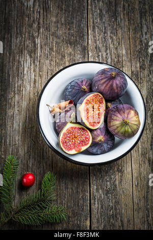 Figues fraîches dans un bol sur fond de bois rustique, high angle view Banque D'Images