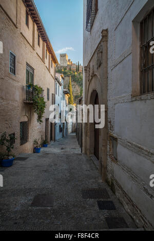 Retour étroite rue près de la rivière Darro, à Grenade avec l'une des tours de l'Alhambra Palace dans la distance magnifiquement allumé Banque D'Images