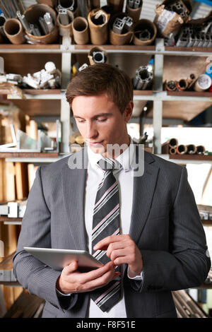 Businessman Checking stock en entrepôt Using Digital Tablet Banque D'Images