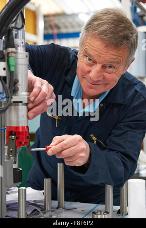 Ingénieur travaillant sur la machine en usine Banque D'Images