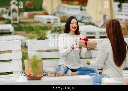 Les filles se jette à l'autre des cadeaux Banque D'Images