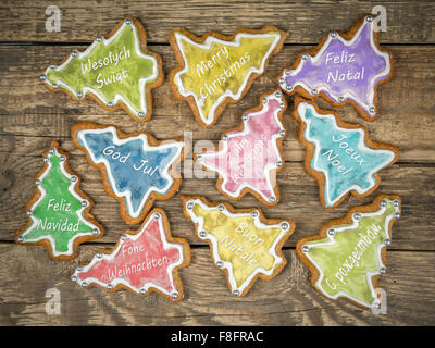 Gingerbread cookies de Noël avec des salutations dans dix langues internationales placées sur des planches rustiques Banque D'Images